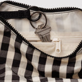 Baggu Crescent Bag Small - Black and Cream Gingham. Close up view of cream interior lining with internal zip and keychain holder. 