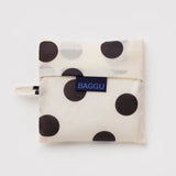Standard Baggu Bag -  Black and Cream Polka Dot. Reusable shopping tote folded up in its compact square case with 'BAGGU" logo tag.
