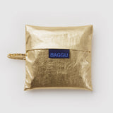 Standard Baggu Bag - Gold Metallic. Reusable shopping tote folded up in compact square case with 'BAGGU" logo tag.