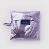 Standard Baggu Bag -  Lavender Metallic. Reusable shopping tote folded up in compact square case with 'BAGGU" logo tag.
