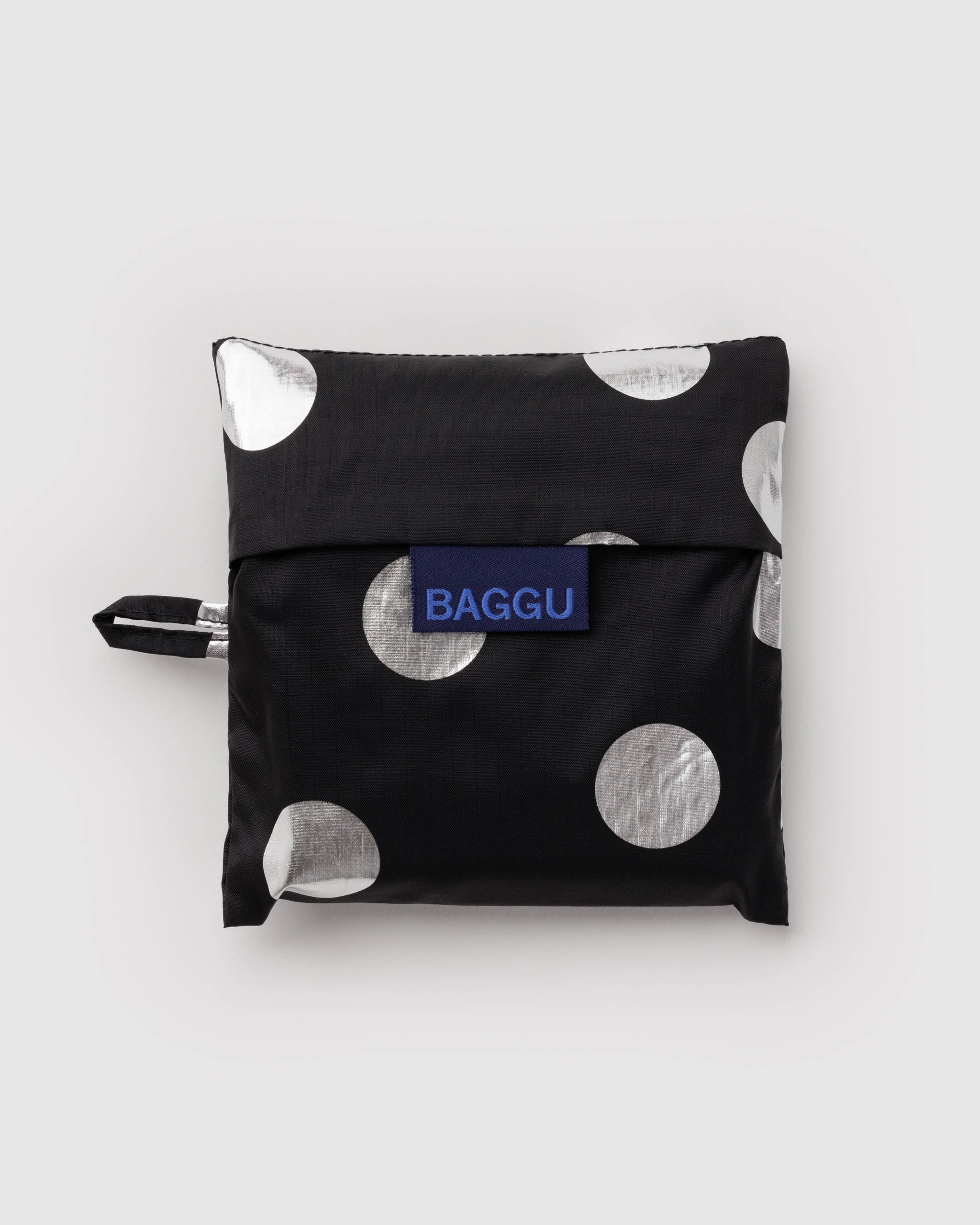 Standard Baggu Bag - Silver Metallic Polka Dot. Reusable shopping tote folded up in compact square case with 'BAGGU" logo tag.