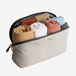 Bellroy 4L Travel packing cube Ash with rolled-up clothes on a white background